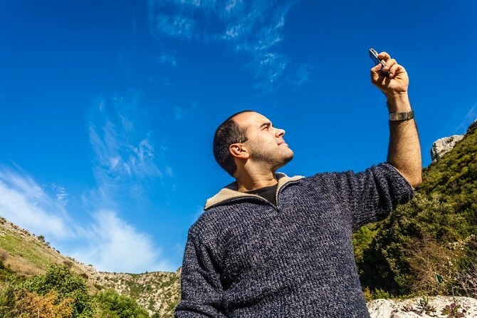 Homme à la recherche d'un signal de téléphone portable