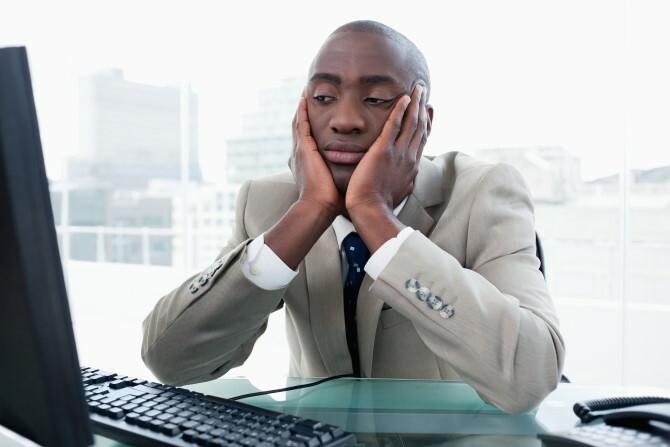 Homme d'affaires s'ennuie en regardant son ordinateur dans son bureau