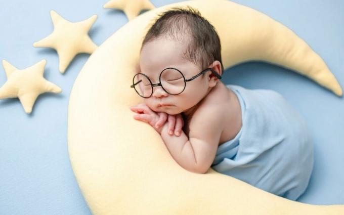 Joli bébé endormi sur un oreiller en forme de lune