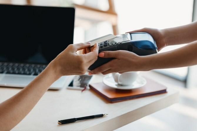 Quelqu'un qui paie des marchandises en utilisant le NFC sur une carte de crédit.