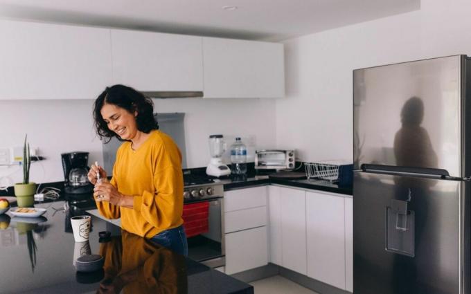 Femme avec haut-parleur intelligent à la maison