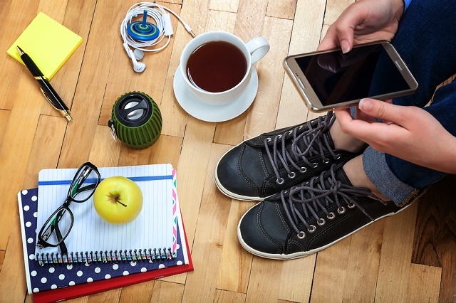 Personne avec smartphone, tasse de café, ordinateur portable, etc.