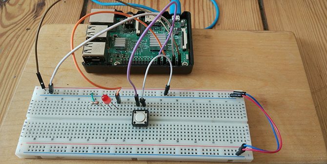 Raspberry Pi connecté à un bouton et à une LED sur une planche à pain.
