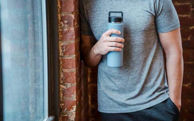 Crop sportif avec une bouteille d'eau